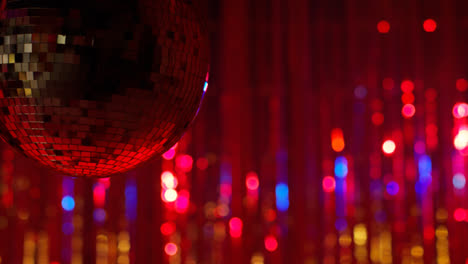 Nahaufnahme-Einer-Rotierenden-Spiegelkugel-In-Einem-Nachtclub-Oder-Einer-Disco-Mit-Blinkender-Stroboskopbeleuchtung-Und-Funkelnden-Lichtern-Im-Hintergrund